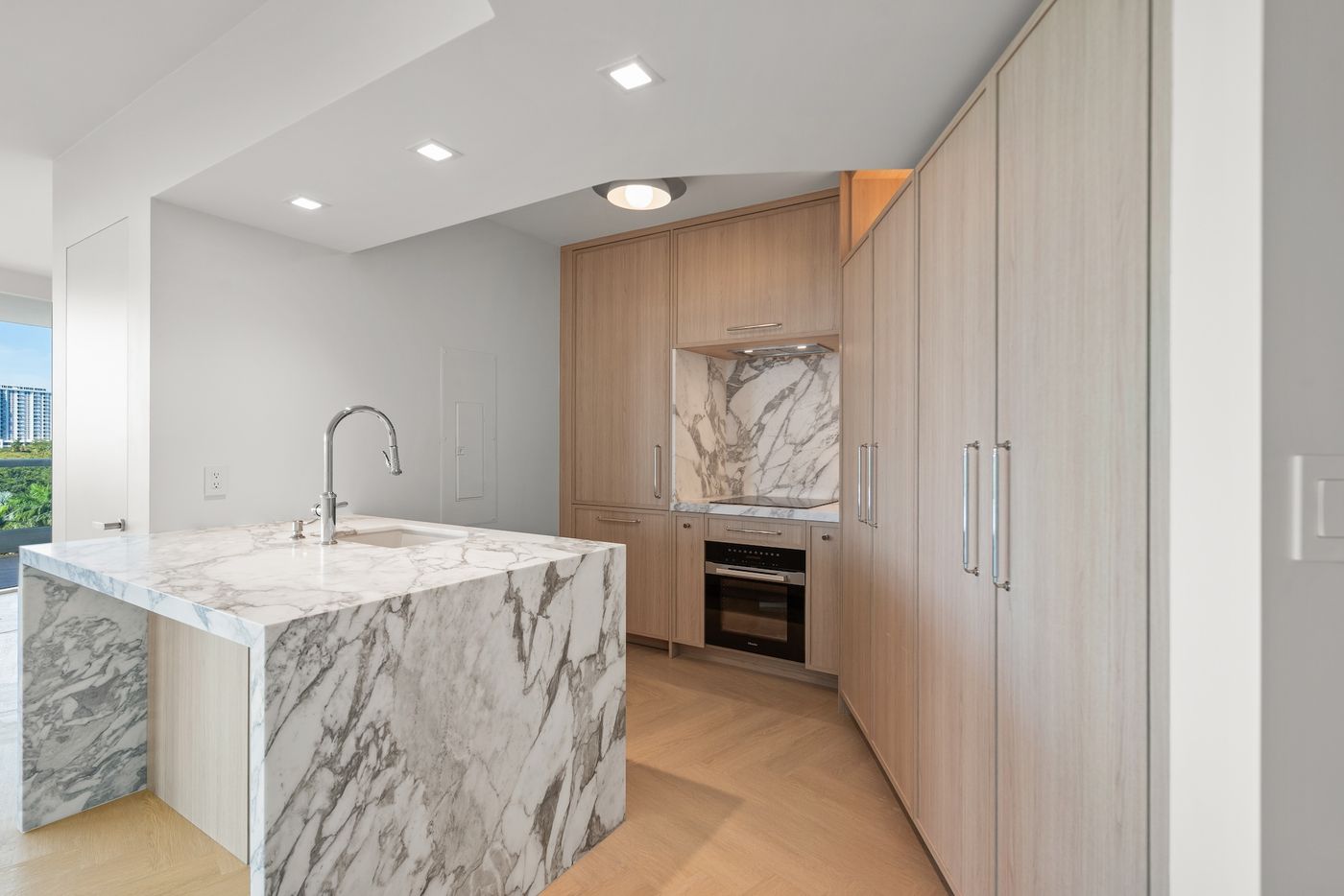 White oak kitchen with marble waterfall island on Brickell Avenue
